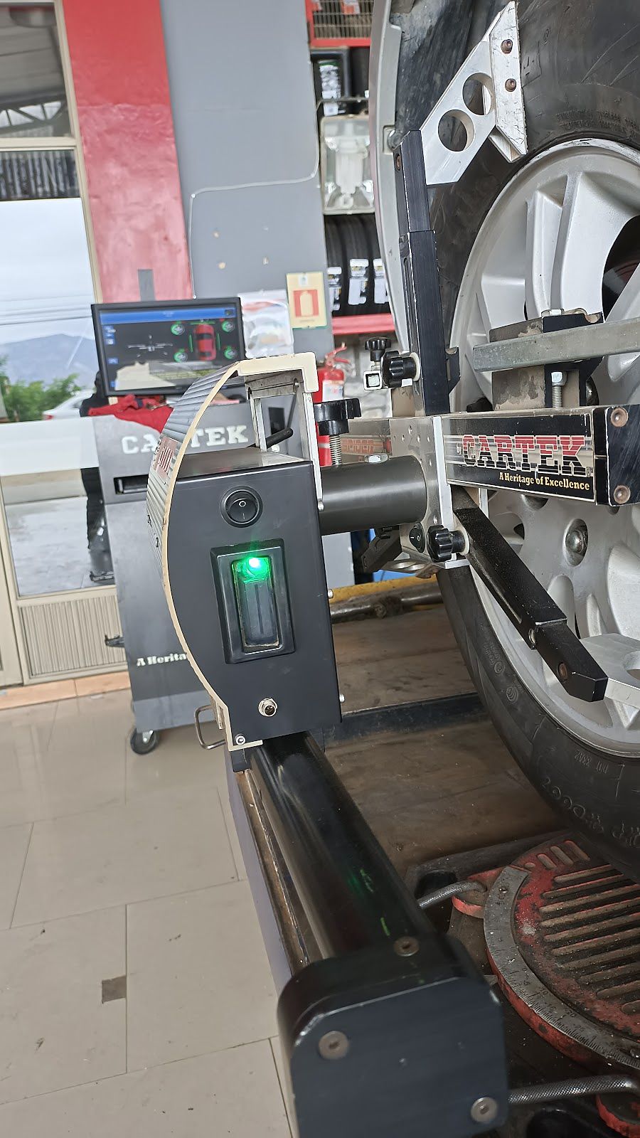 Cabezal Cartek de alineación sujeto a una rueda, con luz verde encendida.