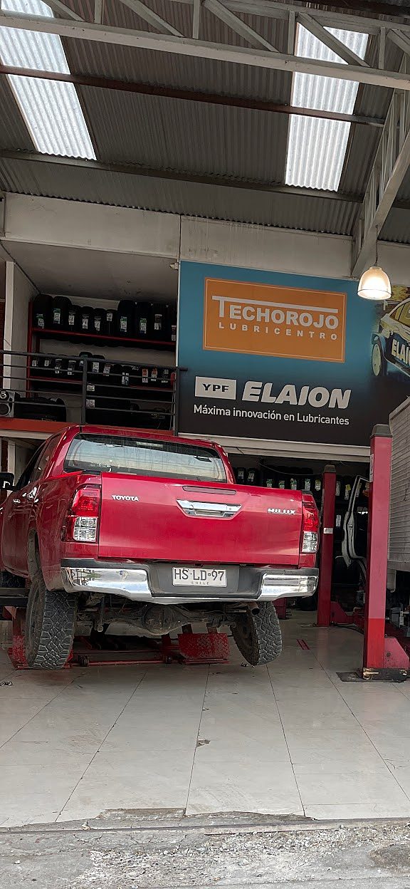 Pickup en elevador bajo el cartel TechoRojo Lubricentro y YPF Elaion.